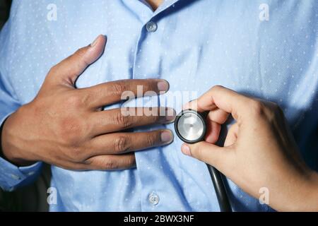 Medico che usa uno stetoscopio corpo di controllo, primo piano Foto Stock