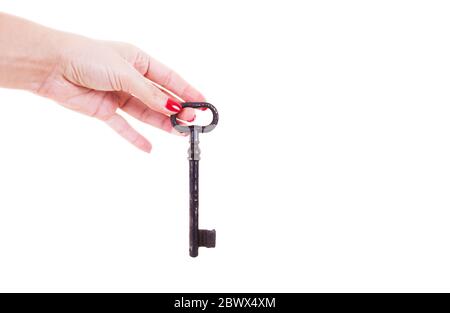 La mano femmina tiene una vecchia chiave. Isolato su sfondo bianco. Foto Stock