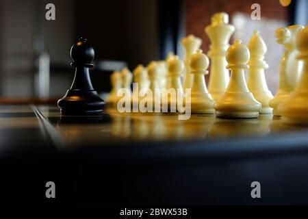 Black Pawn rivolto contro i pezzi bianchi, adatto per il concetto di business. Foto Stock