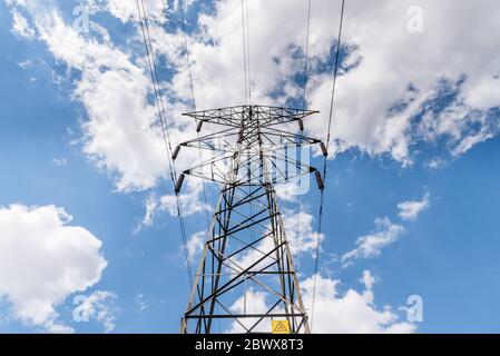 Linee ad alta tensione che girano sul lato sinistro del campo. Morsetto ad alta tensione o torre ad alta tensione Foto Stock