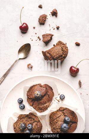 Muffin al cioccolato fresco fatti in casa con frutti di bosco e pezzi di cioccolato. Foto Stock