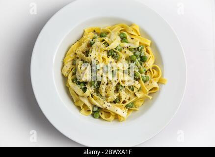 Tagliatelli con limone e Piselli su piastra bianca Foto Stock