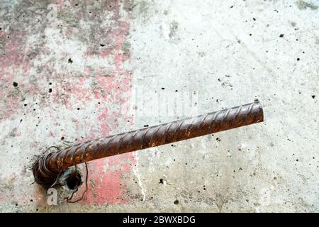 Barra di acciaio strutturale sporgente dalla parete di calcestruzzo. Foto Stock