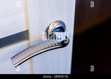 Chiusura della maniglia metallica della porta su porta di legno Foto Stock