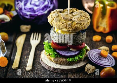 Hamburger gustoso e vegano di riso e verdure, su rustico sfondo di legno. Alimenti vegani senza carne o prodotti animali. Foto Stock