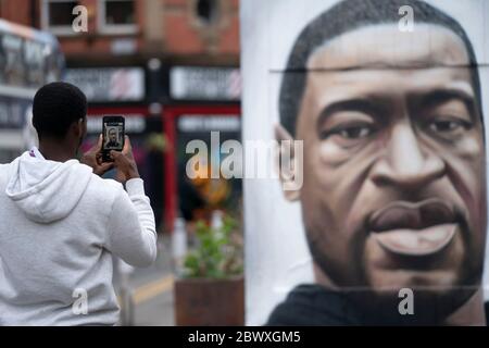 Manchester, Regno Unito. 3 Giugno 2020. Un membro del pubblico scatta una fotografia di un murale di George Floyd, l'uomo nero di 46 anni, morto a Minneapolis, Minnesota, il 25 maggio dopo che Derek Chauvin, un ufficiale bianco del Dipartimento di polizia di Minneapolis, ha premuto il ginocchio al collo di Floyd, Manchester, Regno Unito. Credit: Jon Super/Alamy Live News. Foto Stock