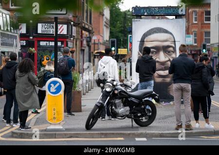 Manchester, Regno Unito. 3 Giugno 2020. I membri del pubblico sono visti da un murale di George Floyd, l'uomo nero di 46 anni, morto a Minneapolis, Minnesota, il 25 maggio dopo che Derek Chauvin, un ufficiale bianco del Dipartimento di polizia di Minneapolis, ha premuto il ginocchio al collo di Floyd, Manchester, Regno Unito. Credit: Jon Super/Alamy Live News. Foto Stock