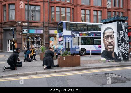 Manchester, Regno Unito. 3 Giugno 2020. I membri del pubblico prendono il ginocchio da un murale di George Floyd, l'uomo nero di 46 anni, morto a Minneapolis, Minnesota, il 25 maggio dopo che Derek Chauvin, un ufficiale bianco del Dipartimento di polizia di Minneapolis, ha premuto il ginocchio al collo di Floyd, Manchester, Regno Unito. Credit: Jon Super/Alamy Live News. Foto Stock