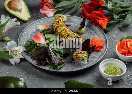 Sushi giapponese - drago verde. Avocado, cipolla, salmone e sushi Foto Stock