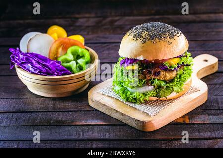 hamburger vegetariano, arrosto e pronto per il consumo. Concetto di vita sana e vegetariana. Spuntino senza carne a base di soia e ceci con verdure fresche Foto Stock