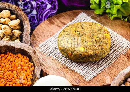 hamburger vegano, arrosto e pronto per il consumo. Concetto di vita sana e vegetariana. Spuntino senza carne a base di soia e ceci con verdure fresche. Foto Stock