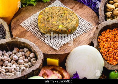 hamburger vegano, arrosto e pronto per il consumo. Concetto di vita sana e vegetariana. Spuntino senza carne a base di soia e ceci con verdure fresche. Foto Stock