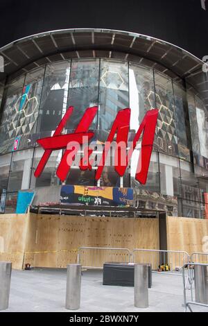 Negozio H & M in Times Square con legno compensato per la protezione dal saccheggio. Foto Stock