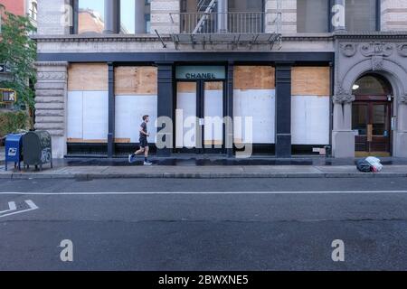 Un uomo scherza da un negozio Chanel a SOHO, a Lower-Manhattan la mattina dopo l'ottavo giorno delle proteste di George Floyd a New York City. Foto Stock