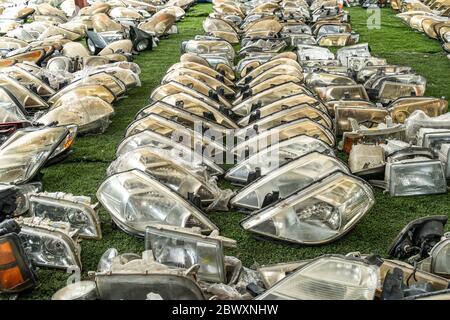 Componenti dei fari usati in vendita nell'area dei rottami Foto Stock