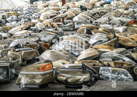 Componenti dei fari usati in vendita nell'area dei rottami Foto Stock