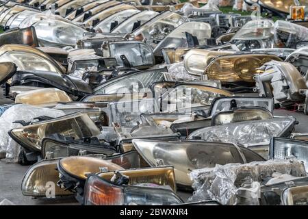Componenti dei fari usati in vendita nell'area dei rottami Foto Stock