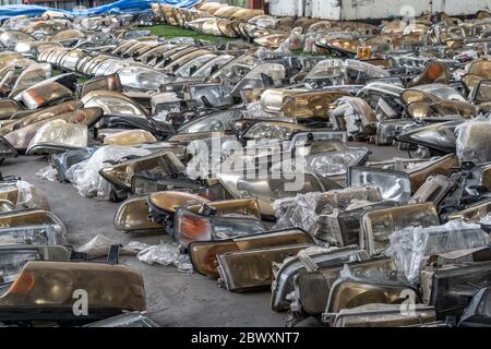 Componenti dei fari usati in vendita nell'area dei rottami Foto Stock
