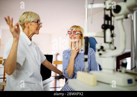 Giovane donna prendendo una visita oculistica esame presso un ottico clinica Foto Stock