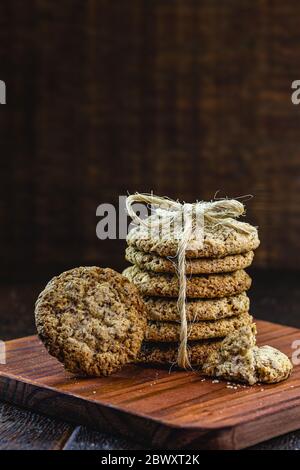 Biscotti interi a grani con cereali, frutta secca e cioccolato su vecchio tavolo di legno Foto Stock