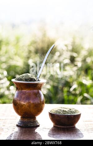 Gaucho yerba mate tè, il chimarão, tipica bevanda brasiliana, tradizionalmente in cuiade bombilla bastone gourd su sfondo di legno. Rio Grande do Foto Stock