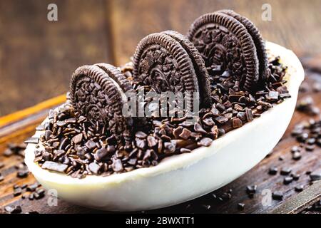 Uovo di cioccolato con ripieno per Pasqua su sfondo di legno. Fuoco selettivo, sfondo in legno. Pasqua 2020. Foto Stock