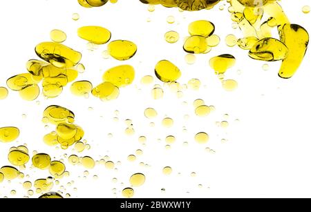 Gocce di olio d'oliva. Immagine astratta di Blob di olio d'oro galleggianti sospesi in acqua. Bolle di closeup isolate su bianco Foto Stock