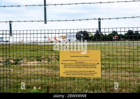 Avviso di violazione della recinzione alla periferia dell'aeroporto di Southend a Londra che consiglia di sanzionare e di legalizzare l'ingresso nelle aree aeroportuali. Foto Stock