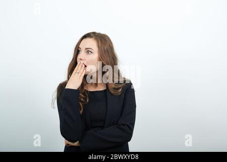 Scioccata e senza parole giovane donna che la ricopre la bocca con le mani. Attraente Foto Stock