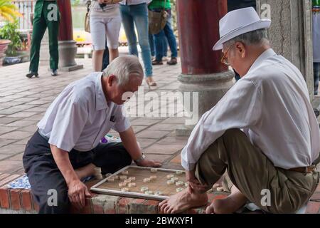 Due uomini anziani che giocano a xiangqi (cờ tướng) nel parco, Hanoi Foto Stock