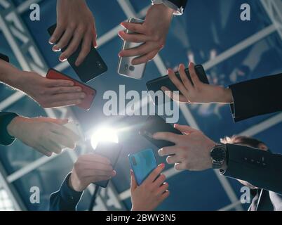 gli smartphone sono nelle mani dei giovani uomini d'affari . Foto Stock