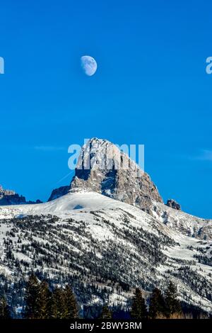 Luna che sorge sul Grand Teton sul versante occidentale della catena montuosa del Teton in Idaho Foto Stock