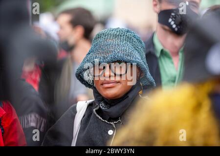 Giovane donna, in una folla di persone, che indossa un cappello e occhiali durante la Black Lives Matter UK protesta marzo. Londra, Inghilterra, Regno Unito Foto Stock