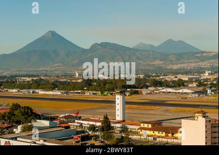 Vista dell'aeroporto internazionale la Aurora di Guatemala City in Guatemala con il vulcano Agua sullo sfondo. Foto Stock