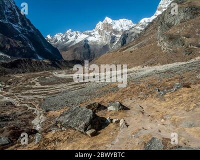 Nepal. Trekking a Mera Peak. Sentiero trekking che guarda giù la valle di Hinku verso l'insediamento di Tagnag e picco 43 Foto Stock