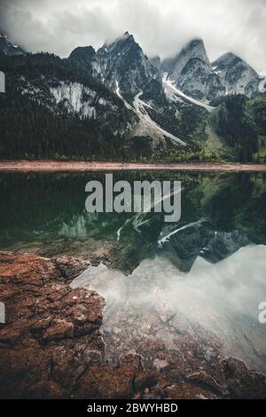 Misty mattina estiva sul lago Vorderer Gosausee. L'alba colorata nelle Alpi austriache, nella regione turistica di Salzkammergut nella Valle di Gosau, nell'alta Austria Foto Stock