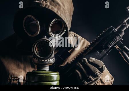 Foto di un uomo stallatore in maschera a gas sovietica con vista in primo piano del fucile da cecchino. Foto Stock