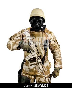 Foto isolata di un soldato completamente attrezzato in uniforme, armatura, casco e maschera a gas in piedi con fucile su sfondo bianco vista frontale. Foto Stock