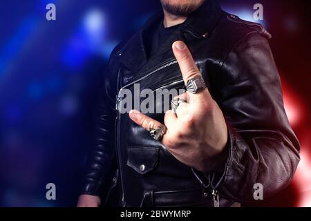 Foto di un uomo in pelle nera giacca biker in piedi su sfondo nero vista posteriore. Foto Stock