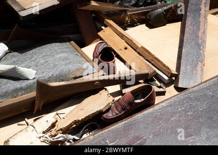 Paio abbandonato di scarpe e vari detriti lasciati dietro. Foto Stock