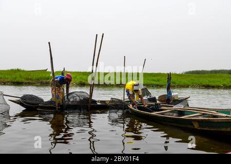 Africa, Africa occidentale, Benin, Lago Nokoue, Ganvié. Pescatori che trasportano le reti sul lago Nokoue, fuori dalla città di Ganvié. Foto Stock