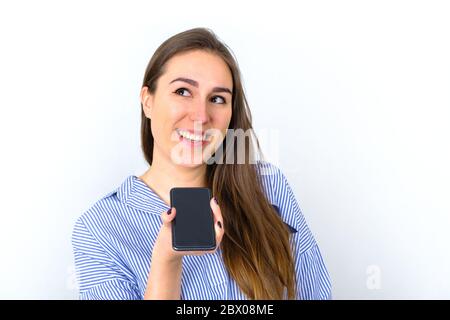 Bella giovane donna che parla su smartphone e sorridente Foto Stock