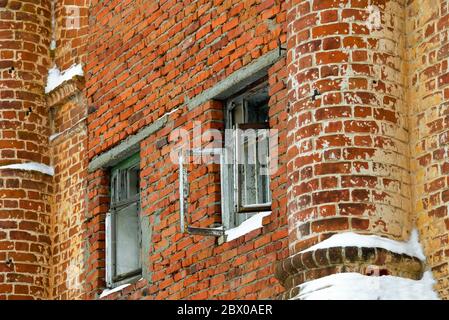 Finestre vuote in un edificio abbandonato in rovina di mattoni rossi Foto Stock