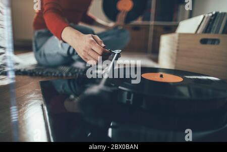 Primo piano di una mano audiophile che gioca un disco in vinile sul giradischi Foto Stock