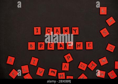 Iscrizione non posso respirare. Segni di protesta. Lettere rosse su quadrati di legno su sfondo nero. Nero vita materia. Foto Stock