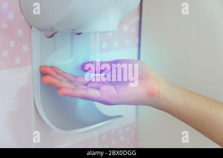 Donna che usa un dispenser automatico di sapone in cucina, primo piano Foto  stock - Alamy