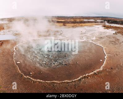 Geyser Valley nel sud-ovest dell'Islanda. La famosa attrazione turistica Geysir. Zona geotermica Haukadalur. Strokkur geyser sulle pendici del Foto Stock