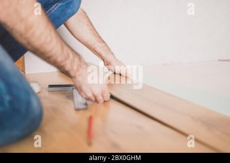 Lavoro di finitura a casa - posa di un nuovo pavimento laminato Foto Stock