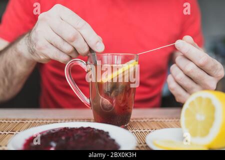 Tè verde in una tazza di vetro trasparente con marmellata e limone - tè allo zenzero Foto Stock