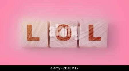 LOL abbreviazione di Laughinf out Loud su blocchi di legno su uno sfondo rosa. Messa a fuoco selettiva. Concetto sociale Foto Stock